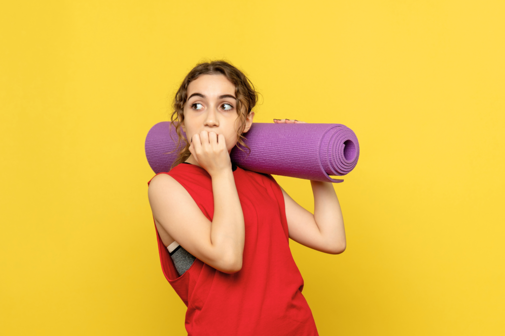 Mujer con tapete de yoga preparándose para una clase de yoga para principiantes